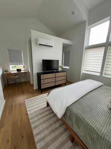 查塔努加Centrally located modern townhome free parking的一间卧室配有一张床和一台平面电视