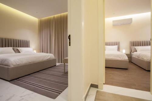 利雅德شقة انيقة وفاخرة بحي العليا Elegant and luxurious apartment Al-Olaya的一间酒店客房,设有两张床和走廊