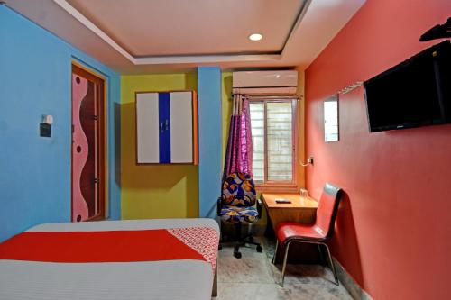 GauripurFlagship Continental Stays Near Netaji Subhash Chandra Bose International Airport的一间卧室配有一张床、一张书桌和一台电视
