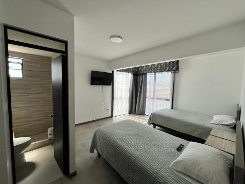 伊基克Hotel Santa María的酒店客房带两张床和一间浴室