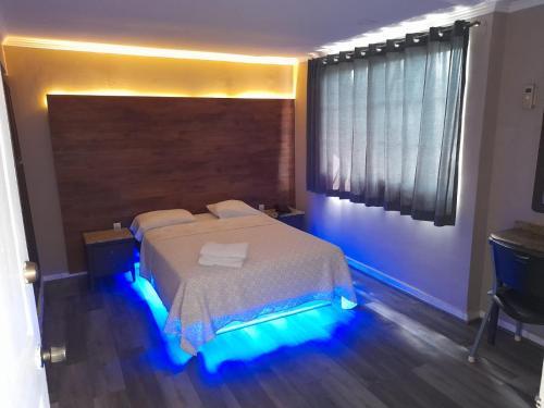 巴拿马城Hotel Dunas的一间卧室配有一张蓝色灯床
