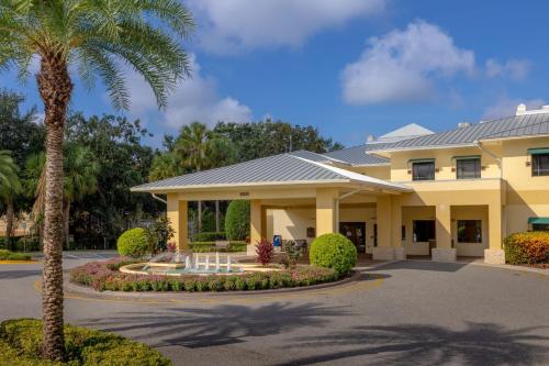 奥兰多Sheraton Vistana Resort Villas, Lake Buena Vista Orlando的棕榈树的大型黄色建筑