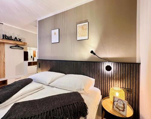 克拉根福BaMo Studio - city living arkaden的一间卧室配有一张大床和木制床头板