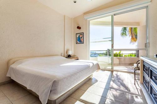 阿卡普尔科Preciosa Villa en Marina Las Brisas的一间卧室设有一张床和一个大窗户