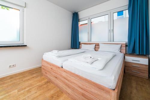 多特蒙德City Rooms Dortmund的一间卧室配有一张带蓝色窗帘的大床