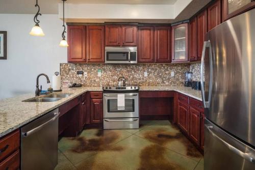 摩押Luxury Downtown Rental (Pet Friendly) - La Dolce Vita Villas #7的厨房配有木制橱柜和不锈钢冰箱。