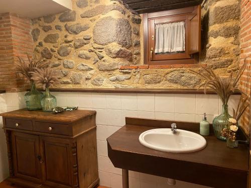 莱德斯马La Clerecia de Ledesma的一间带水槽和石墙的浴室