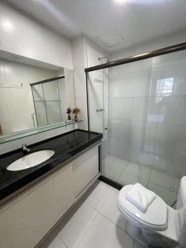 伊波茹卡Flat com vista para piscina principal的带淋浴、盥洗盆和卫生间的浴室