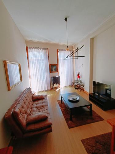 波尔图Porto Saudade的客厅配有真皮沙发和茶几