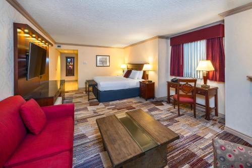 班夫Royal Canadian Lodge的酒店客房,配有一张床和一张红色的沙发