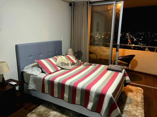 圣克鲁斯Apartamento en ubicación Estratégica的一间卧室配有一张带条纹毯子的床和窗户