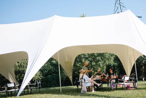 卡缅涅茨-波多利斯基Rodynnyi Maietok Family Estate的一群人坐在帐篷里的桌子上