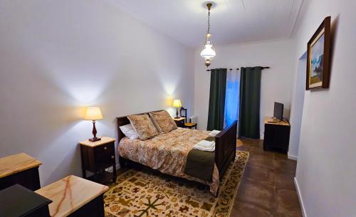 蓬塔德尔加达Casa da Abelheira的一间卧室配有床、两张桌子和一台电视
