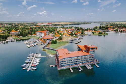 米科瓦伊基Hotel Mikołajki Leisure & SPA - Destigo Hotels的享有码头的空中景色,在水中划船