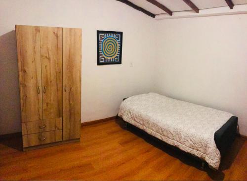 马尼萨莱斯Alojamiento Cuarto Espiral的一间卧室配有一张床和一个木制橱柜