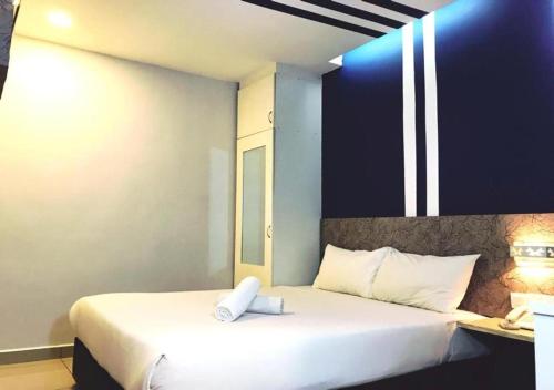 吉隆坡Mozu Hotel Sri Hartamas的一间卧室配有一张带白色枕头的床