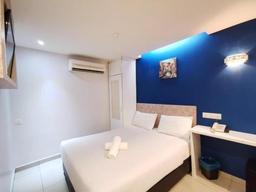 吉隆坡Mozu Hotel Sri Hartamas的小房间设有床和蓝色的墙壁