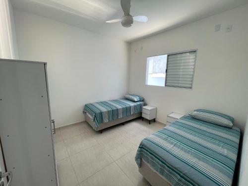 卡拉瓜塔图巴Casa nova e móveis novos的一间卧室配有两张床和吊扇