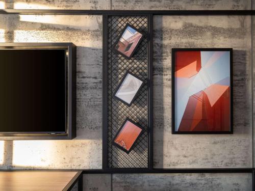 伦敦伦敦伯爵府宜必思酒店的墙上有两张画框和电视