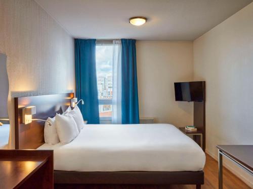 圣但尼巴黎圣但尼普莱耶尔阿德吉奥公寓式酒店的一间设有大床和窗户的酒店客房
