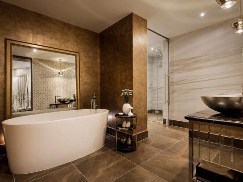 惠灵顿惠灵顿索菲特酒店的一间带大浴缸和水槽的浴室