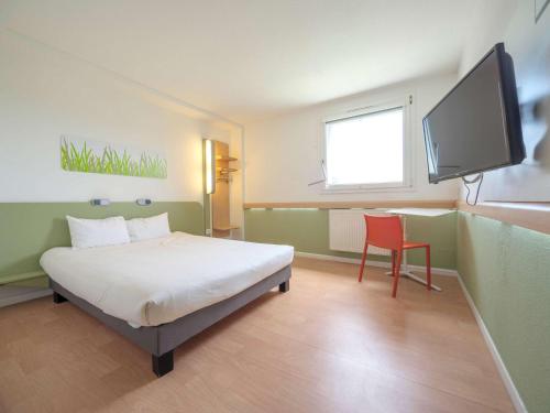 萨尔堡萨尔堡布尔宜必思快捷酒店 的一间卧室配有一张床和一台平面电视