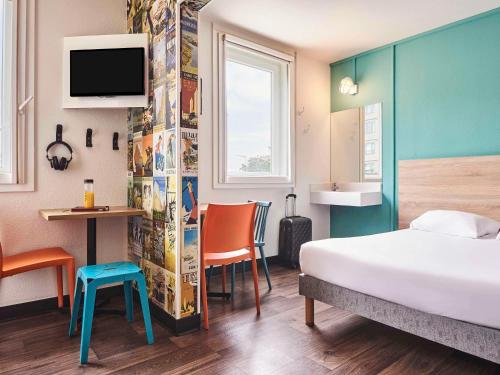 鲁瓦西昂法兰西hotelF1 Roissy CDG Pn2的酒店客房设有一张床、一张书桌和一台电视机。