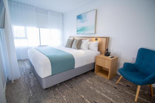 埃尔利海滩Club Wyndham Airlie Beach的一间卧室配有一张床和一张蓝色椅子
