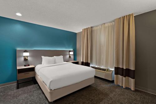 桑蒂桑蒂凯富套房及酒店的卧室配有白色的床和蓝色的墙壁