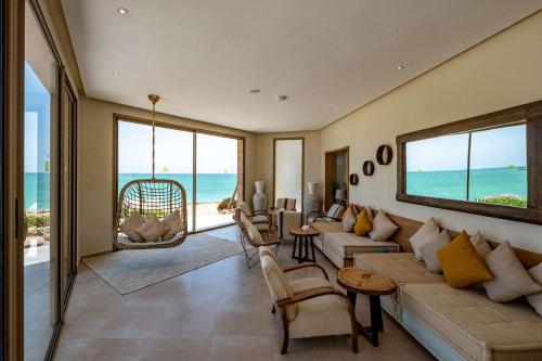 达赫拉Dakhla South Bay的一间带沙发和椅子的客厅,享有海景。