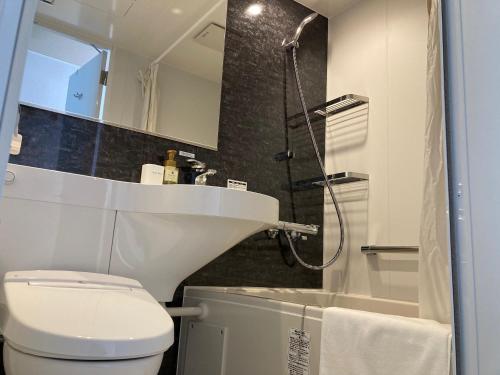 小樽RJ HOTELS OTARU的浴室配有卫生间、盥洗盆和淋浴。