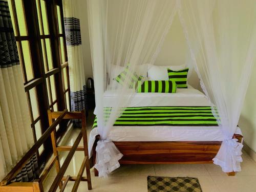 埃拉Ella South Star的卧室配有带绿色和白色枕头的天蓬床