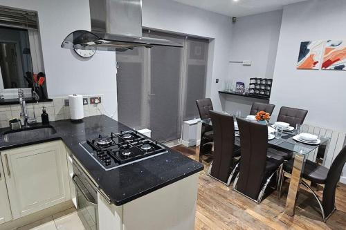 The HydeCozy & Elegant 4 Bedroom Home Near Wembley的厨房配有炉灶和桌椅