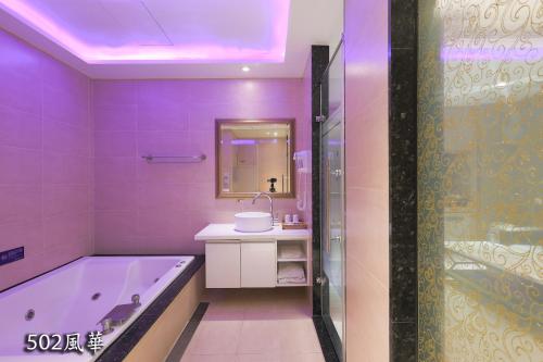 中坜奇美国际时尚旅馆的紫色浴室设有浴缸和水槽