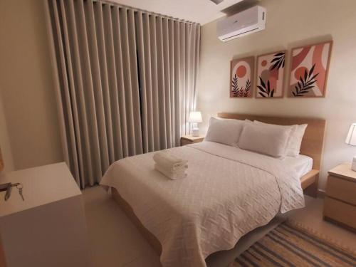 博卡奇卡Escapada en Boca chica的卧室配有白色的床和窗户。