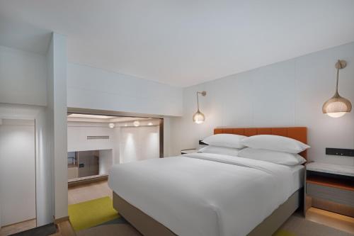 重庆重庆南岸希尔顿惠庭酒店的卧室配有白色大床和白色枕头