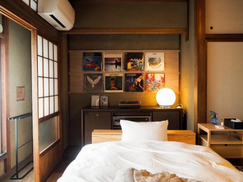 舞鹤市ゲストホテル宰嘉庵あおい/GuestHotelSAIKAAN_AOI的一间卧室配有一张床和一张带台灯的桌子