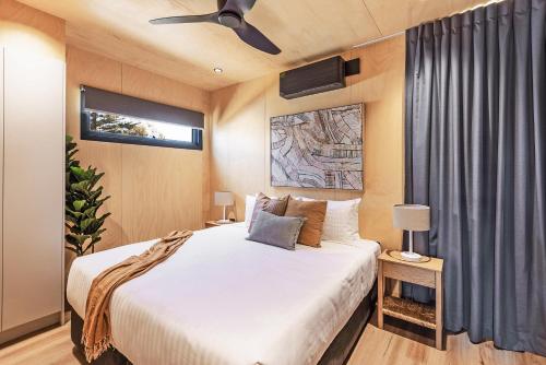 霍克斯内斯特Reflections Hawks Nest - Holiday Park的一间卧室配有一张床和吊扇