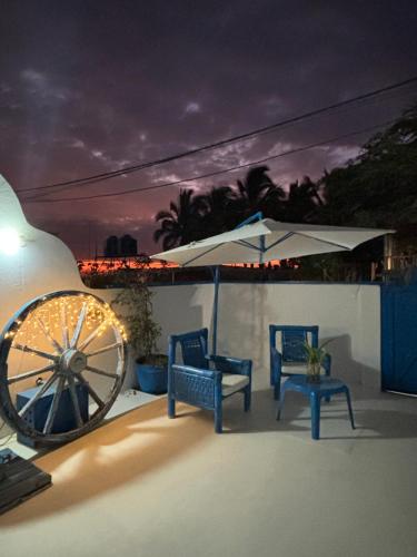 维加伊托Villa Aqua Boutique Vichayito的庭院设有两把椅子、一把伞和轮子