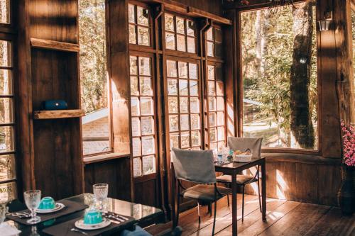 坎波斯杜若尔当Pousada Villa Serena的用餐室设有桌椅和窗户。
