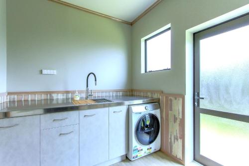 罗托鲁瓦Spacious retreat with Mountain View的洗衣房配有洗衣机和窗户