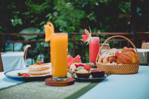 乌布The Sebali Resort的一张桌子,上面放着一盘食物和两杯橙汁