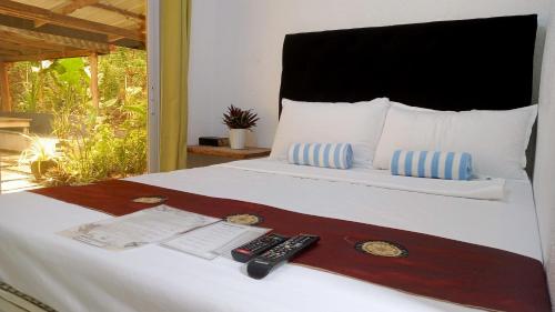 LaurelBaywalk Suites Batangas的一间卧室配有一张带两个遥控器的床
