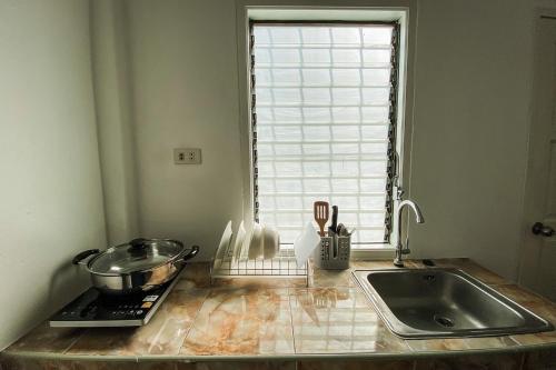 甲米镇House No.2 Village的带水槽的厨房台面和窗户