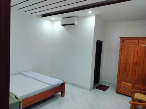 Ấp Cái GiáKhách sạn Gia Nghiêm 2的一间卧室配有一张床和一个木制橱柜