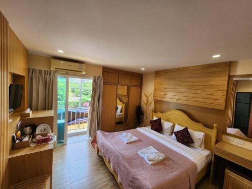 芭东海滩Alaita Hostel Patong的酒店客房设有一张大床和电视