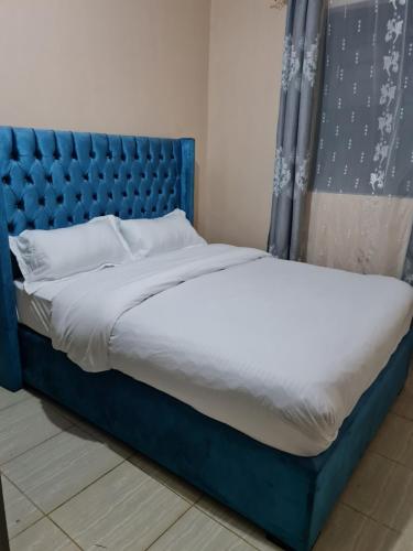 BometLa Ribera Cosy Homes的一张带蓝色床头板的睡床