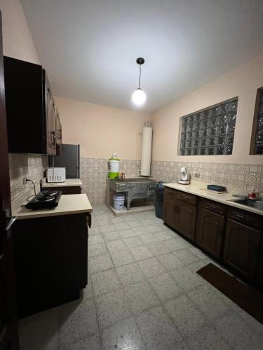 危地马拉Casa Xibalba的一间设有黑色橱柜和白色台面的大厨房