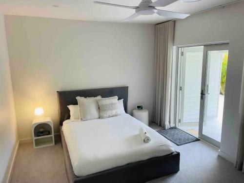 瓦布利尔Ocean Lake Oasis的卧室配有白色的床和吊扇