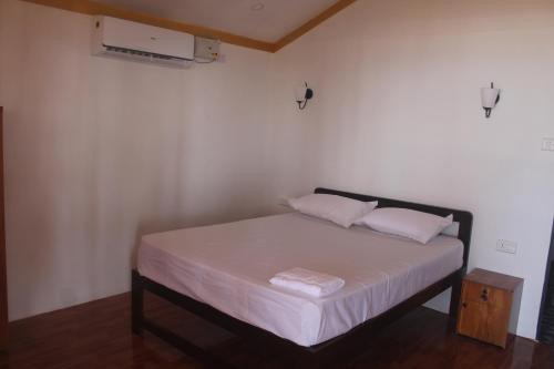 卡纳科纳Nikhil's Beach Cottages的一间卧室配有带白色床单和枕头的床。